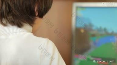 一个十几岁的男孩在家里玩桌面电脑游戏